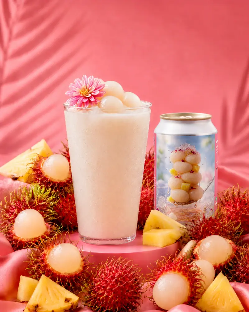Creamy lychee sour poured beside fresh rambutan and pineapple